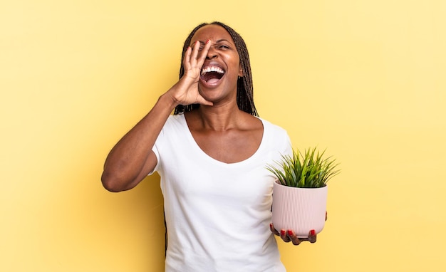 Feeling happy, excited and positive, giving a big shout out with hands next to mouth, calling out holding a plant pot