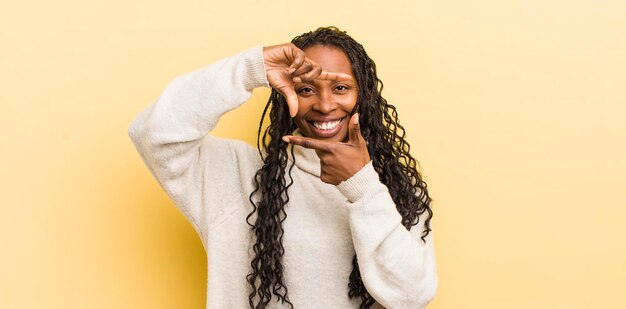 Feeling happy friendly and positive smiling and making a portrait or photo frame with hands