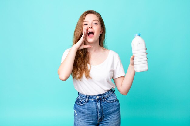 Feeling happy,giving a big shout out with hands next to mouth and holding a milk bottle