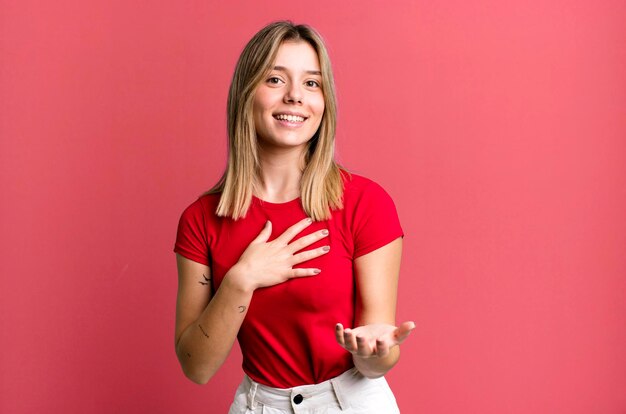 Feeling happy and in love smiling with one hand next to heart and the other stretched up front