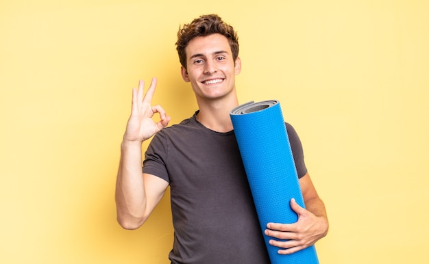 feeling happy, relaxed and satisfied, showing approval with okay gesture, smiling. yoga mat concept