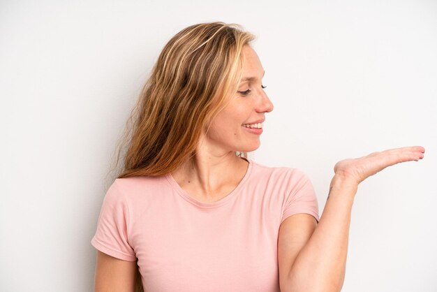 Sentendosi felice e sorridente guardando casualmente un oggetto o un concetto tenuto sulla mano sul lato