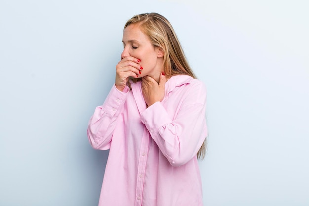 喉の痛みとインフルエンザの症状で気分が悪くなり、口を覆って咳をする