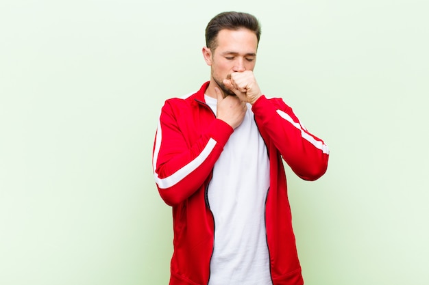 feeling ill with a sore throat and flu symptoms, coughing with mouth covered