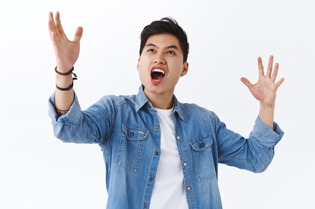 Feeling might and power. Portrait of passionate, excited asian man describing something tremendous and amazing, triumphing, cheering becoming champion