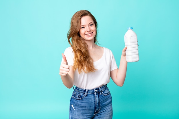 Sentirsi orgogliosi, sorridere positivamente con il pollice in alto e tenere in mano una bottiglia di latte