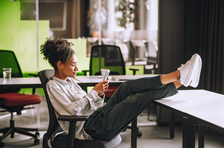 Feeling relaxed. Woman sitting in the office with her legs on the table