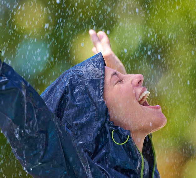 Чувство возрождения под дождем обрезанный снимок молодой женщины, счастливо стоящей под дождем в плаще