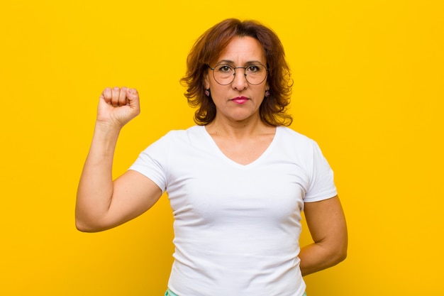 Photo feeling serious, strong and rebellious, raising fist up, protesting or fighting for revolution