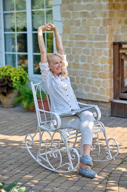 Feeling sleepy. a woman sitting in the chair and\
stretching