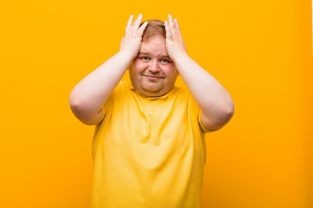 Foto sentirsi stressati e ansiosi, depressi e frustrati dal mal di testa, alzando entrambe le mani alla testa