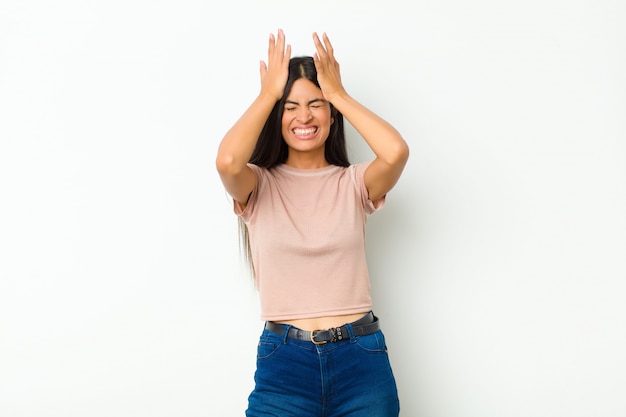 feeling stressed and anxious, depressed and frustrated with a headache, raising both hands to head