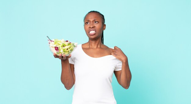 Feeling stressed, anxious, tired and frustrated and holding a salad