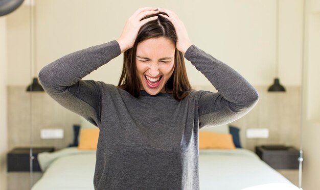 Foto sensazione di stress e frustrazione alzando le mani alla testa sensazione di stanchezza infelice e con emicrania