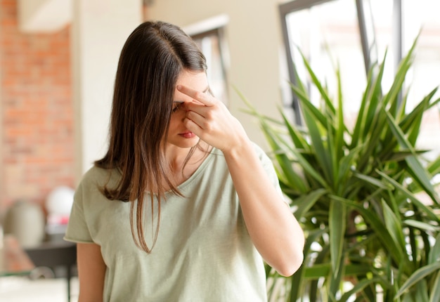 Foto sentirsi stressati, infelici e frustrati toccando la fronte e soffrendo di emicrania o forte mal di testa