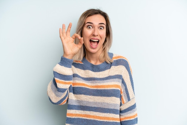 Foto sentendosi di successo e soddisfatto sorridente con la bocca spalancata facendo segno giusto con la mano