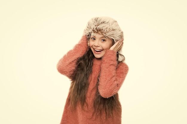 Feeling warm Caring fur garments Child long hair soft hat enjoy softness Winter fashion concept Warm hat for cold weather Kid girl wear hat with ear flaps white background Soft furry accessory