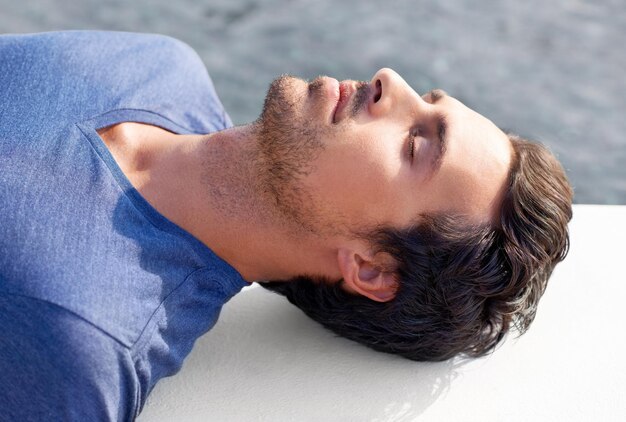 Feeling the warmth of the sun on my skin Cropped shot of a handsome man lying down with his eyes closed