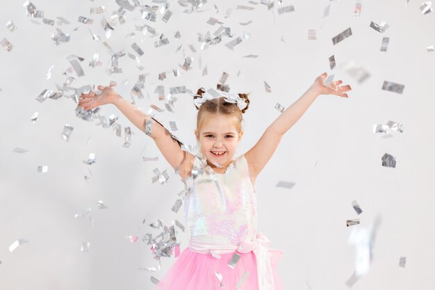 Feest, vakantie, verjaardag, nieuwjaar en vieringsconcept - schattig kind dat confetti gooit.