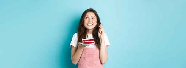 Feestdagen en viering hoopvol jong meisje dat verjaardag viert en opkijkt en vingers kruist om te gaan