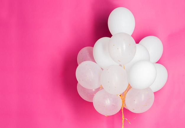 feestdagen, verjaardag, feest en decoratie concept - close-up van opgeblazen witte heliumballonnen op roze achtergrond