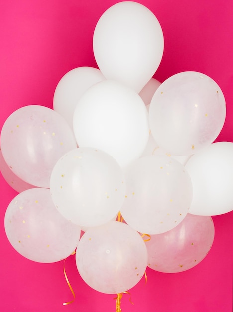 feestdagen, verjaardag, feest en decoratie concept - close-up van opgeblazen witte heliumballonnen op roze achtergrond