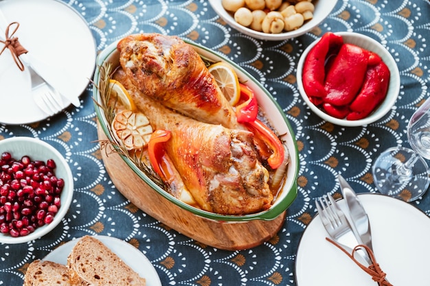 Foto feestelijk gerecht voor thanksgiving geroosterde kalkoenpoten met groenten op een tafel met snacks