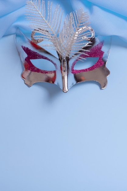 Feestelijk gezichtsmasker voor carnaval of maskerade feest op gekleurde achtergrond Carnaval achtergrond bovenaanzicht plat leggen
