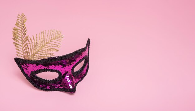 Feestelijk gezichtsmasker voor carnavalviering op gekleurde achtergrond met kopieerruimte