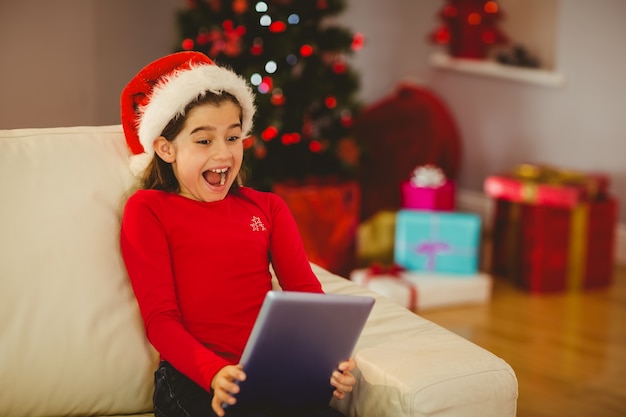 Feestelijk meisje die tabletpc op laag met behulp van