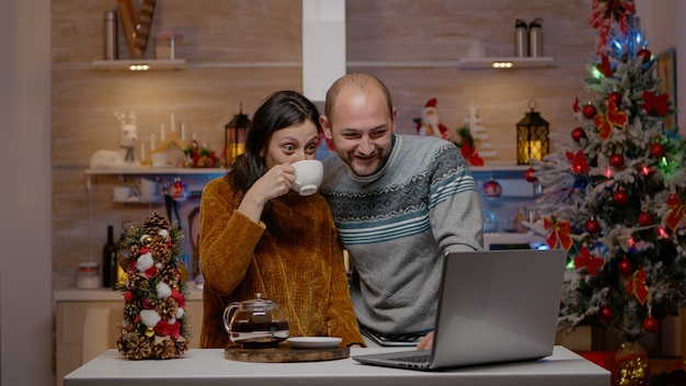 Feestelijk paar dat videogesprekcommunicatie op laptop gebruikt