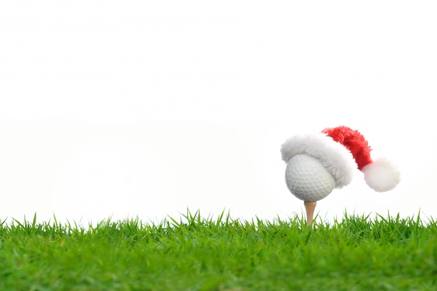 Feestelijk uitziende golfbal op T-stuk met de hoed van Santa Claus op bovenkant voor vakantieseizoen op wit wordt geïsoleerd dat