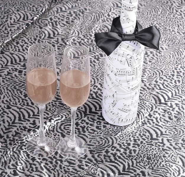 Feestelijk versierde fles wijn en twee glazen op kanten tabl