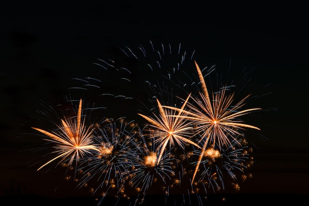 Feestelijk vuurwerk in de nachtelijke hemel. Heldere veelkleurige begroeting op een zwarte achtergrond. Plaats voor tekst.