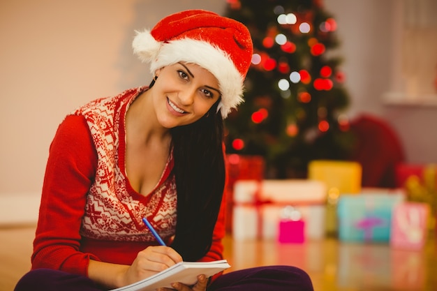 Feestelijke brunette die haar lijst schrijft