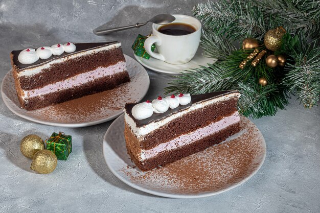 Feestelijke cake met chocolade en krokante tussenlaag. twee porties. op een grijze achtergrond. verjaardag, feestdagen, snoep. kopieer ruimte.