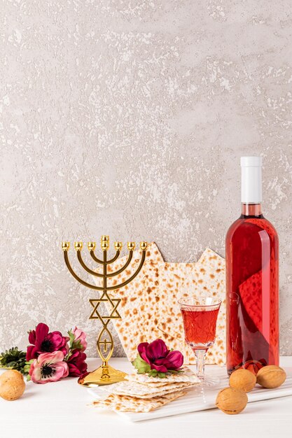 Feestelijke compositie voor het Joodse Pascha Een fles kosher wijn matzoth een kristalglas wijn een traditionele gouden kandelaar menorah.