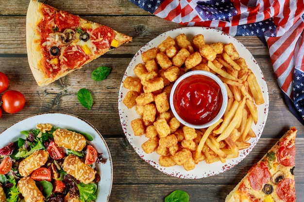 Feestelijke feesttafel met gebakken aardappel, pizza en groente voor amerikaanse vakantie.