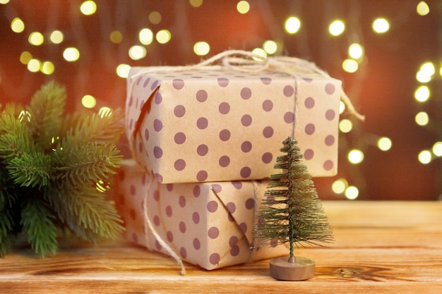 Foto feestelijke geschenkdoos op houten tafel tegen bruine bokeh achtergrond