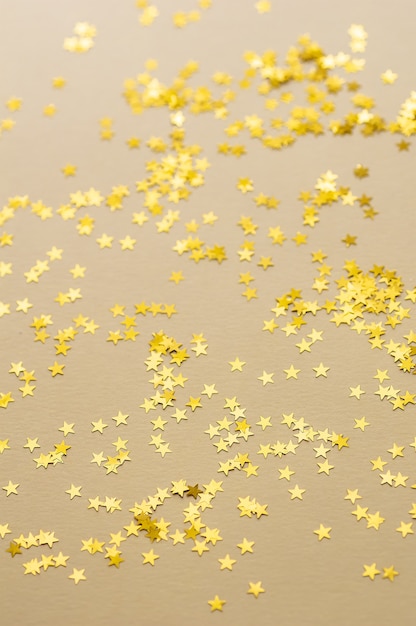 Feestelijke gouden sterren van confetti zijn verspreid op een lichte achtergrond.