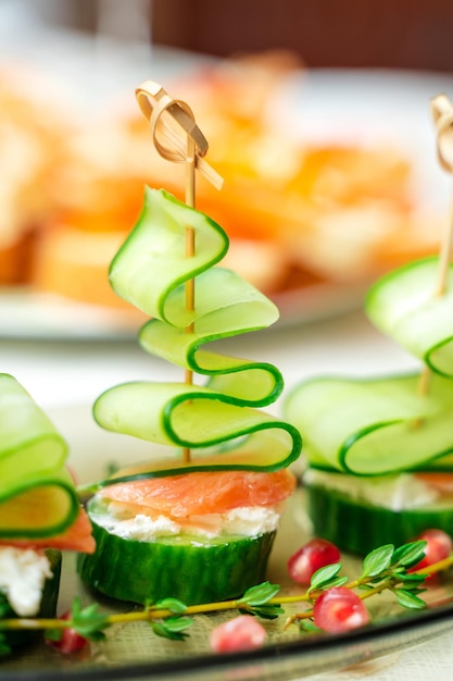 Foto feestelijke hapjes met zalm en komkommer in de vorm van een kerstboom op een familievakantietafel