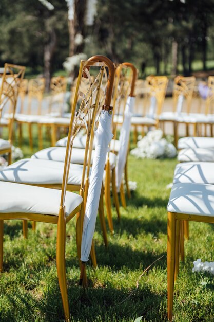 Feestelijke huwelijksceremonie. Opknoping paraplu op een lege stoel.