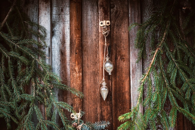 Feestelijke kerst raamdecoratie met dennentakken, slingers en kegels. Merry Christmas-teken en kerstballen op de vensterbank