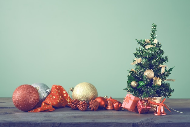 Feestelijke kerstboom staat op donkere planken.