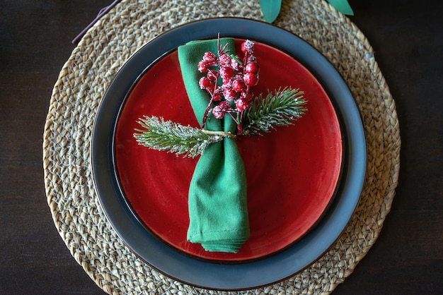 Foto feestelijke kersttafel met groen servet versierd met een takje met bessen en dennentak