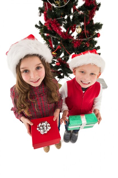 Feestelijke kleine broers en zussen glimlachen op camera houden geschenken