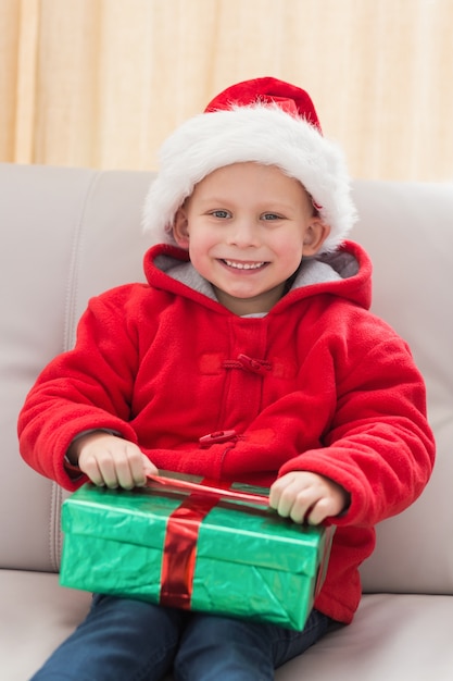 Feestelijke kleine jongen die een geschenk opent