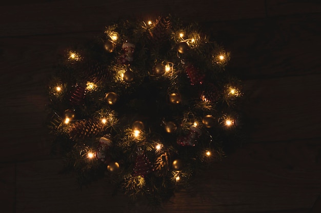 Foto feestelijke krans met speelgoed elektrische verlichting van slingers op een kerst- en nieuwjaarsdecoratie