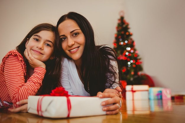 Feestelijke moeder en dochter die bij camera glimlachen