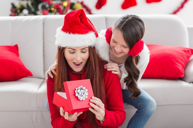 Feestelijke moeder en dochter met een kerstcadeau